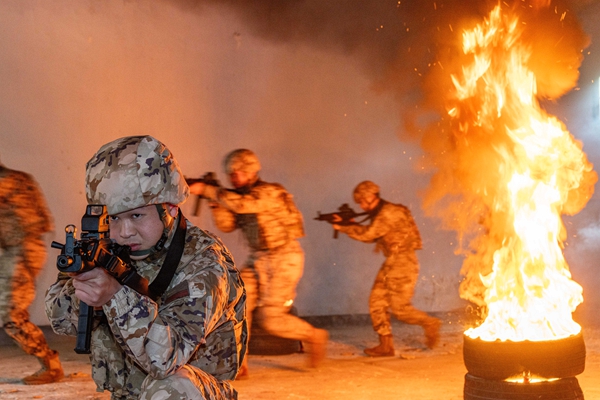 武警官兵在交替掩护通过火障。