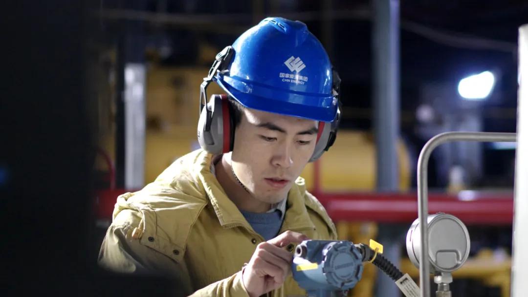 春节期间,电厂运行人员在检查设备表计。