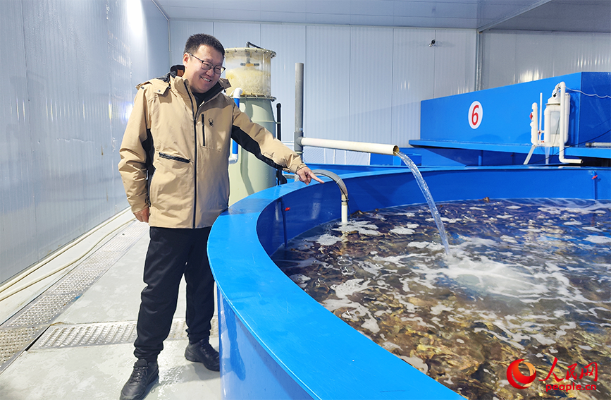边建伟介绍暂养池的水温和盐度。人民网记者 郭维瑾摄
